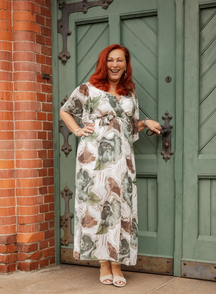 Petra steht im festlichen Kleid for einer meditteran anmutenden Tür